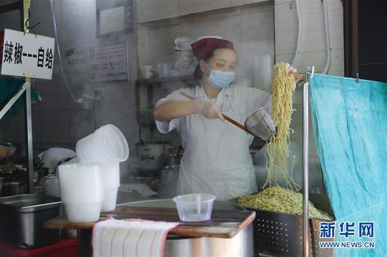 4月22日，武漢市糧道街的家陽“趙師傅”天天紅油熱干面店廚師在制作熱干面。新華社記者 沈伯韓 攝