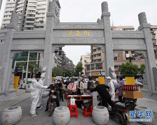  4月16日，進(jìn)出武漢漢正街步行街的人員在掃描健康碼。新華社記者 王毓國 攝